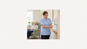Prevenirea infecțiilor în îngrijire: îngrijitoare care își dezinfectează mâinile într-un cămin din UK